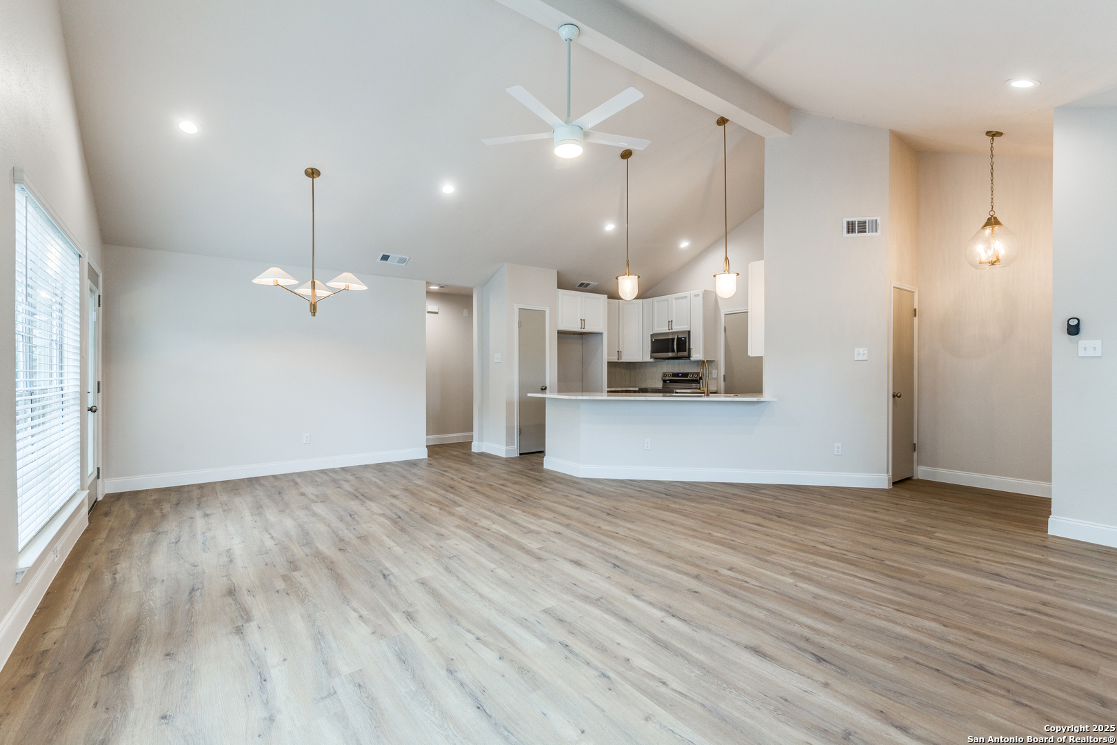 wooden floor in an empty room with a kitchen
