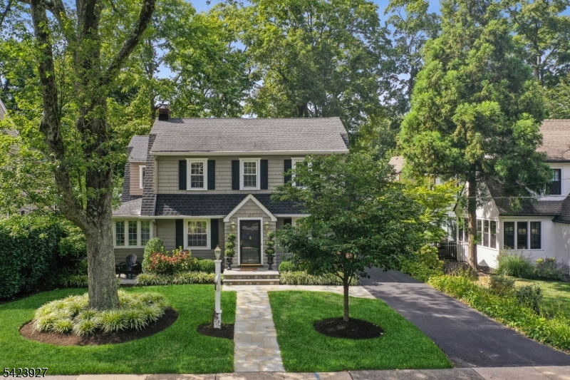 a front view of a house with a yard and a garden