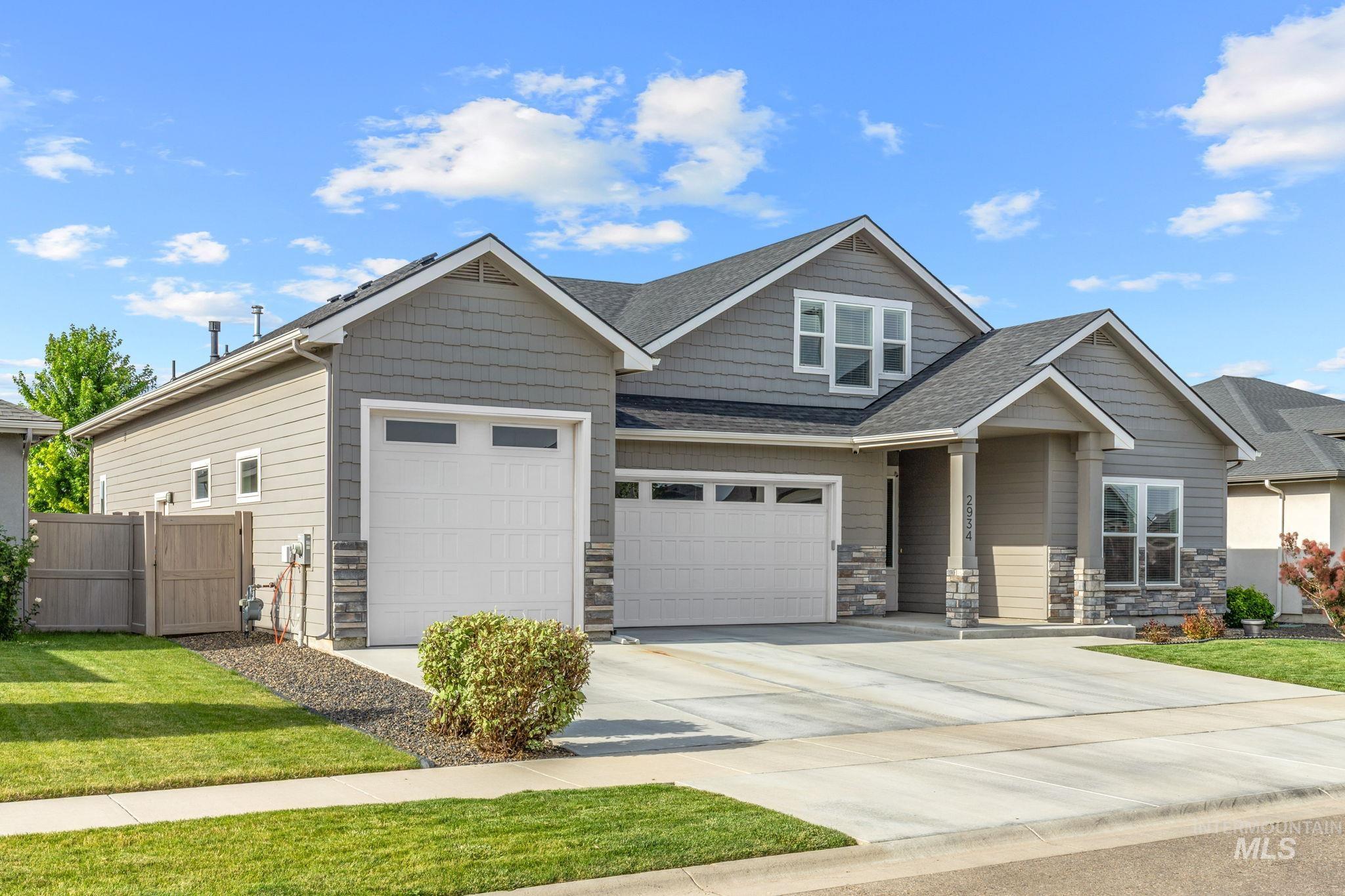 2934 East Murchison Street Meridian, ID 83642 - Photo 2 of 44 Contemporary gray exterior with decorative stone accents, a multi-car driveway, and a four car garage.