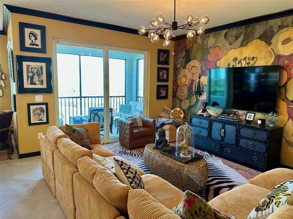 a living room with furniture a flat screen tv and a floor to ceiling window