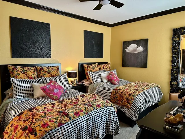 a bedroom with two beds and painting on the wall