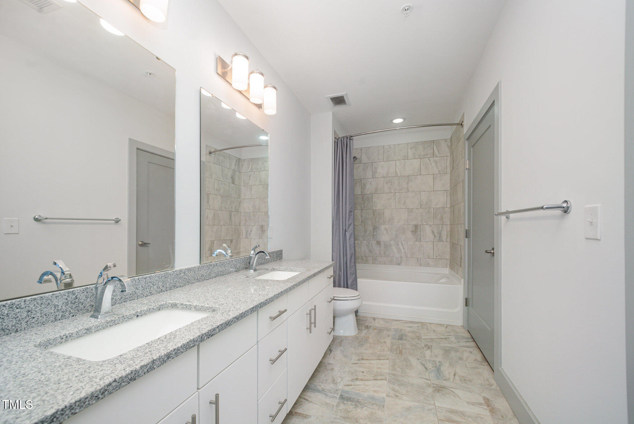 1300 St Marys Street, Unit 408 Raleigh, NC 27605 - Photo 17 of 28 a bathroom with a granite countertop sink mirror bathtub and shower
