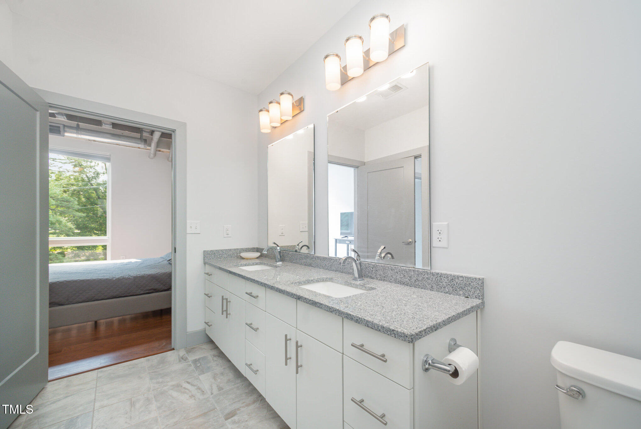 1300 St Marys Street, Unit 408 Raleigh, NC 27605 - Photo 18 of 28 a bathroom with a granite countertop sink and a mirror