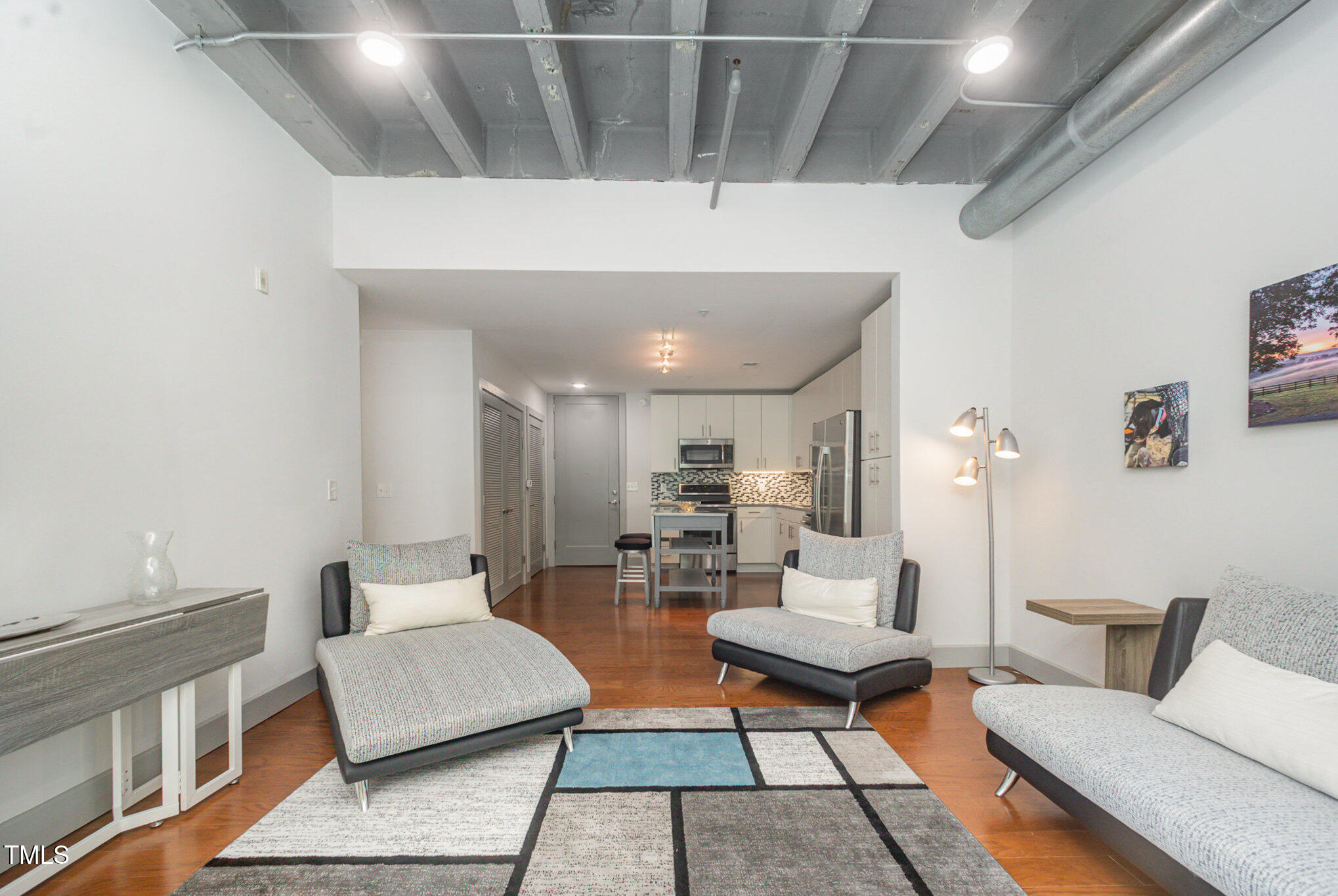 1300 St Marys Street, Unit 408 Raleigh, NC 27605 - Photo 4 of 28 a living room with lots of furniture and a rug