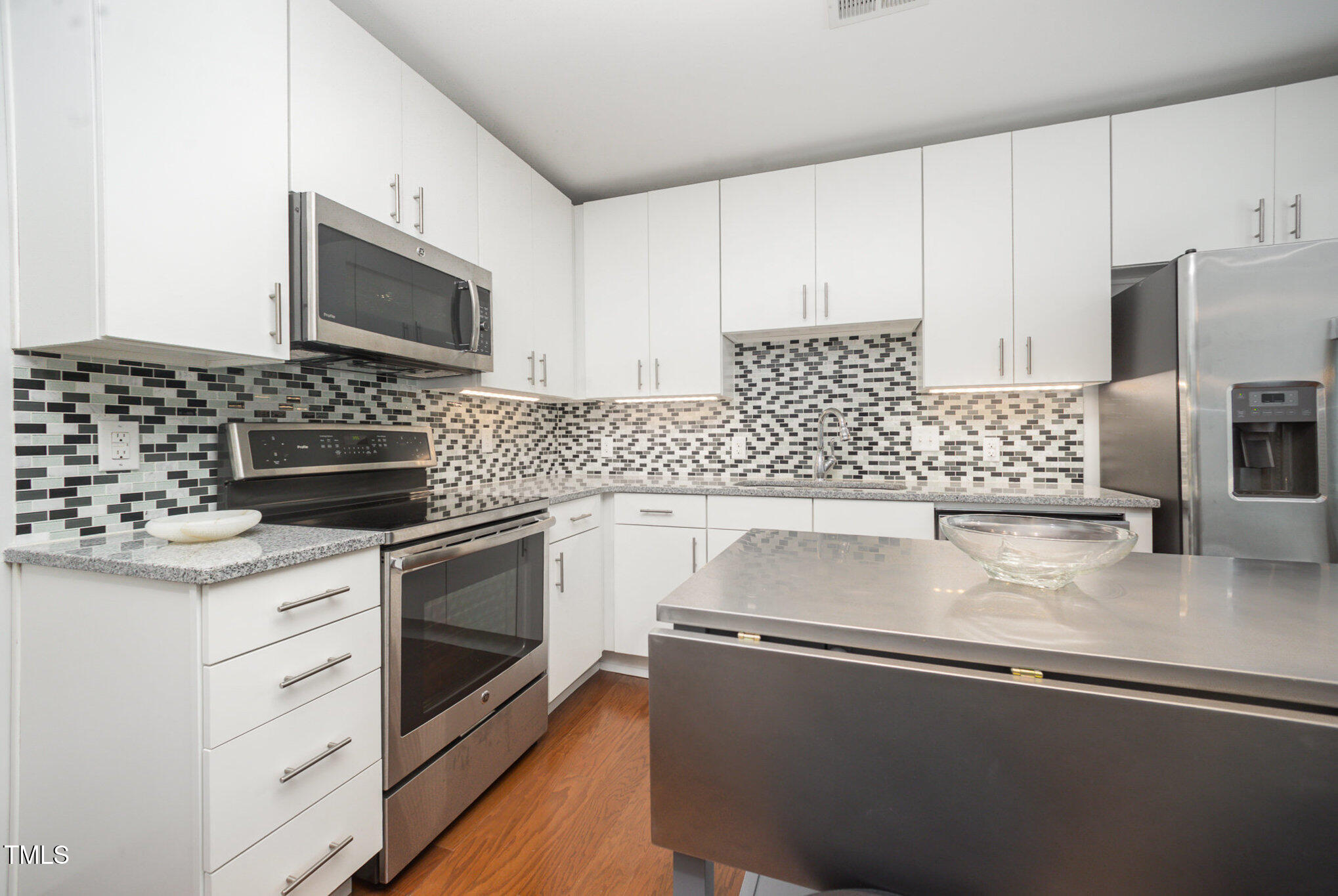1300 St Marys Street, Unit 408 Raleigh, NC 27605 - Photo 5 of 28 a kitchen with granite countertop a sink stove and microwave