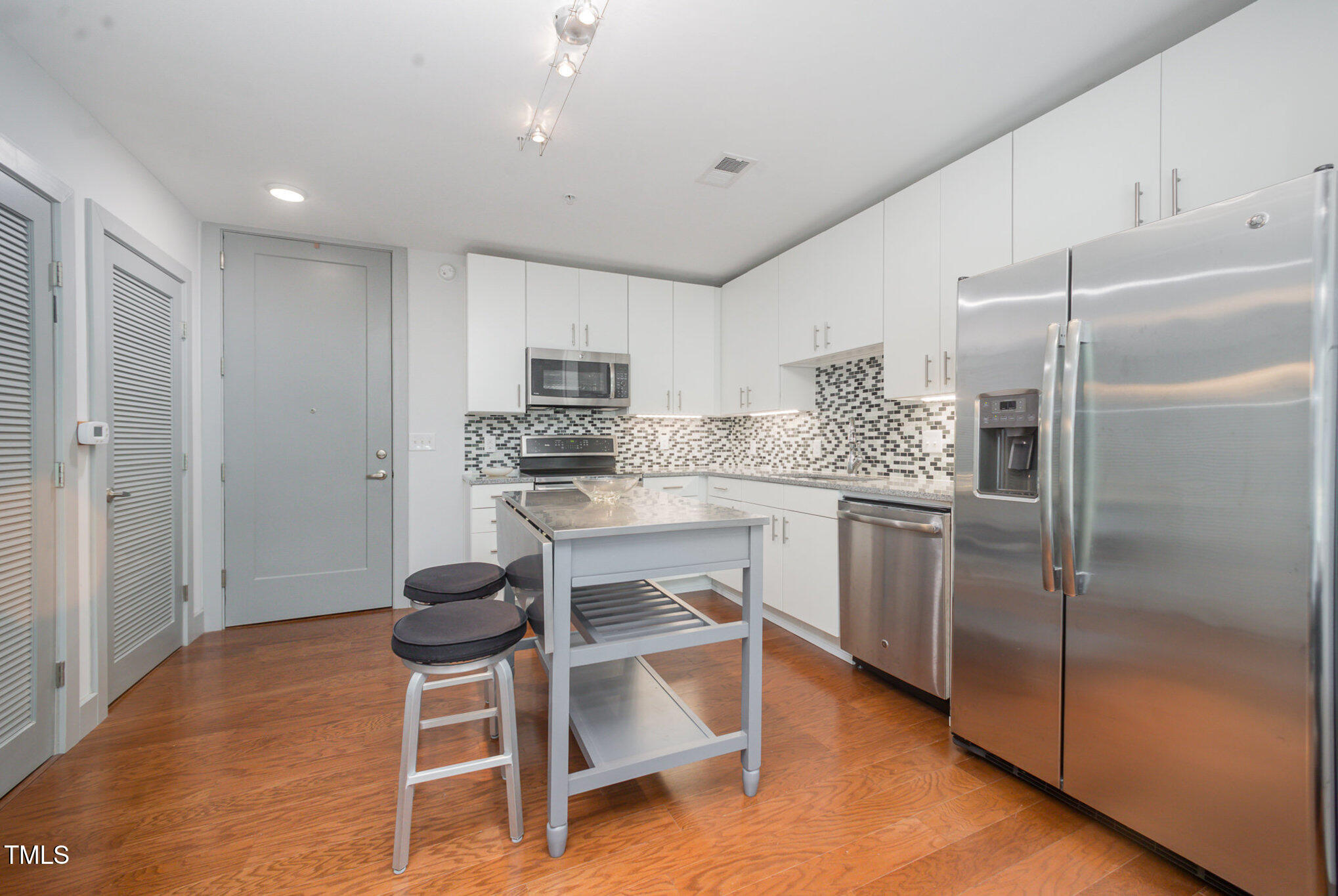 1300 St Marys Street, Unit 408 Raleigh, NC 27605 - Photo 6 of 28 a kitchen with kitchen island a counter top space cabinets and stainless steel appliances