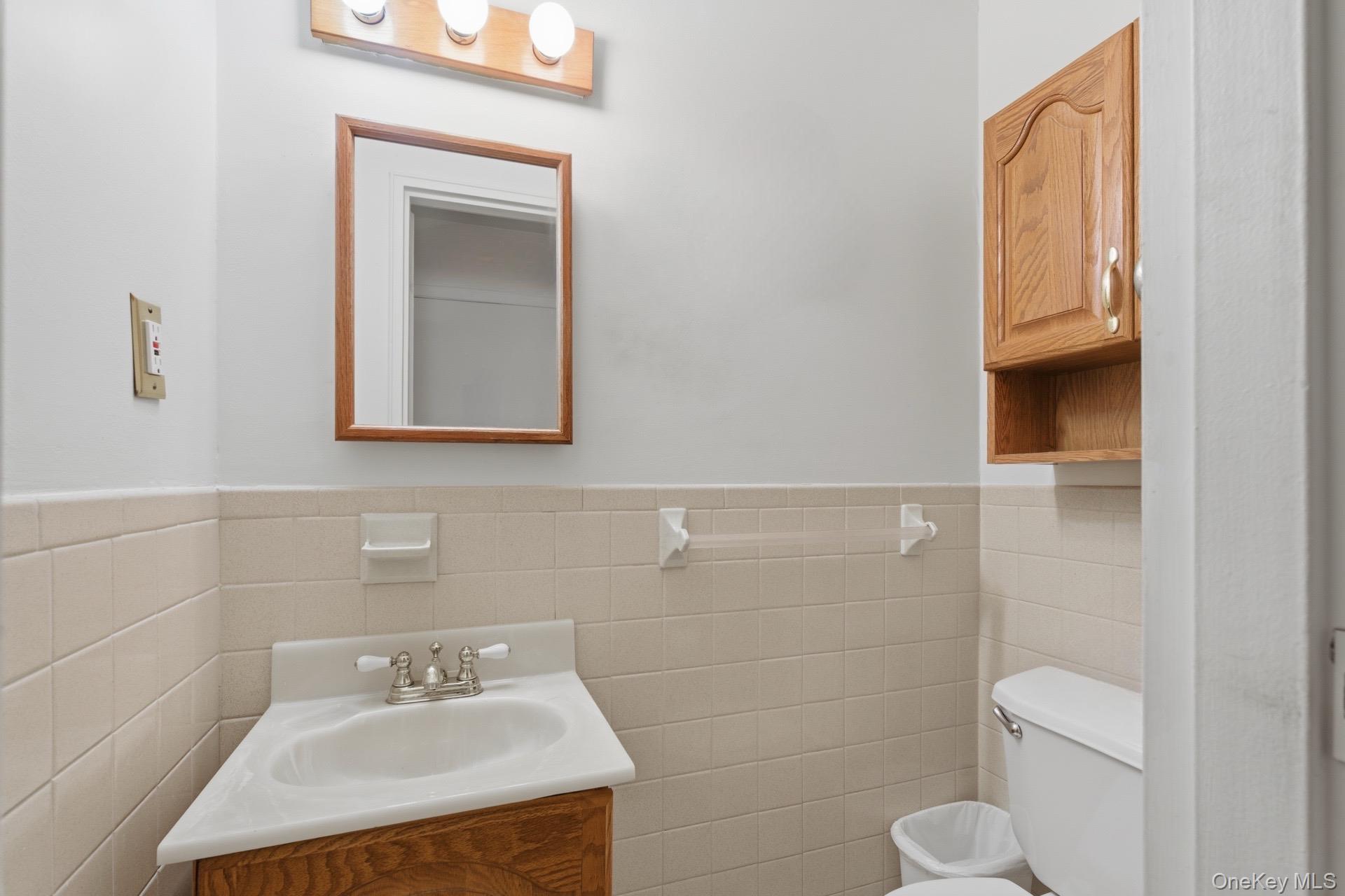 313 Mariners Way Copiague, NY 11726 - Photo 11 of 25 a bathroom with a sink toilet and mirror