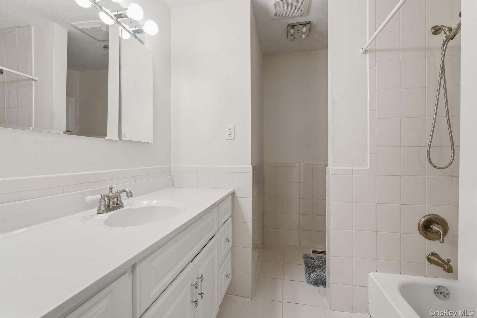 313 Mariners Way Copiague, NY 11726 - Photo 12 of 25 a bathroom with a sink a vanity a mirror and shower
