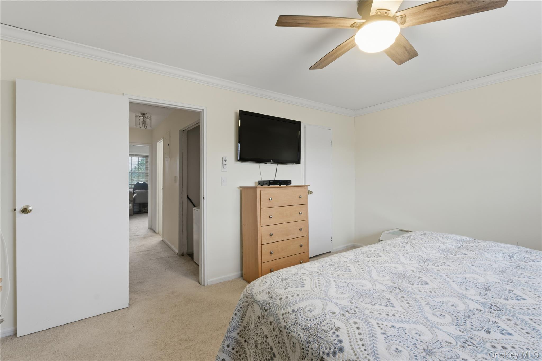 313 Mariners Way Copiague, NY 11726 - Photo 17 of 25 a bedroom with a bed and a flat tv screen on a dresser