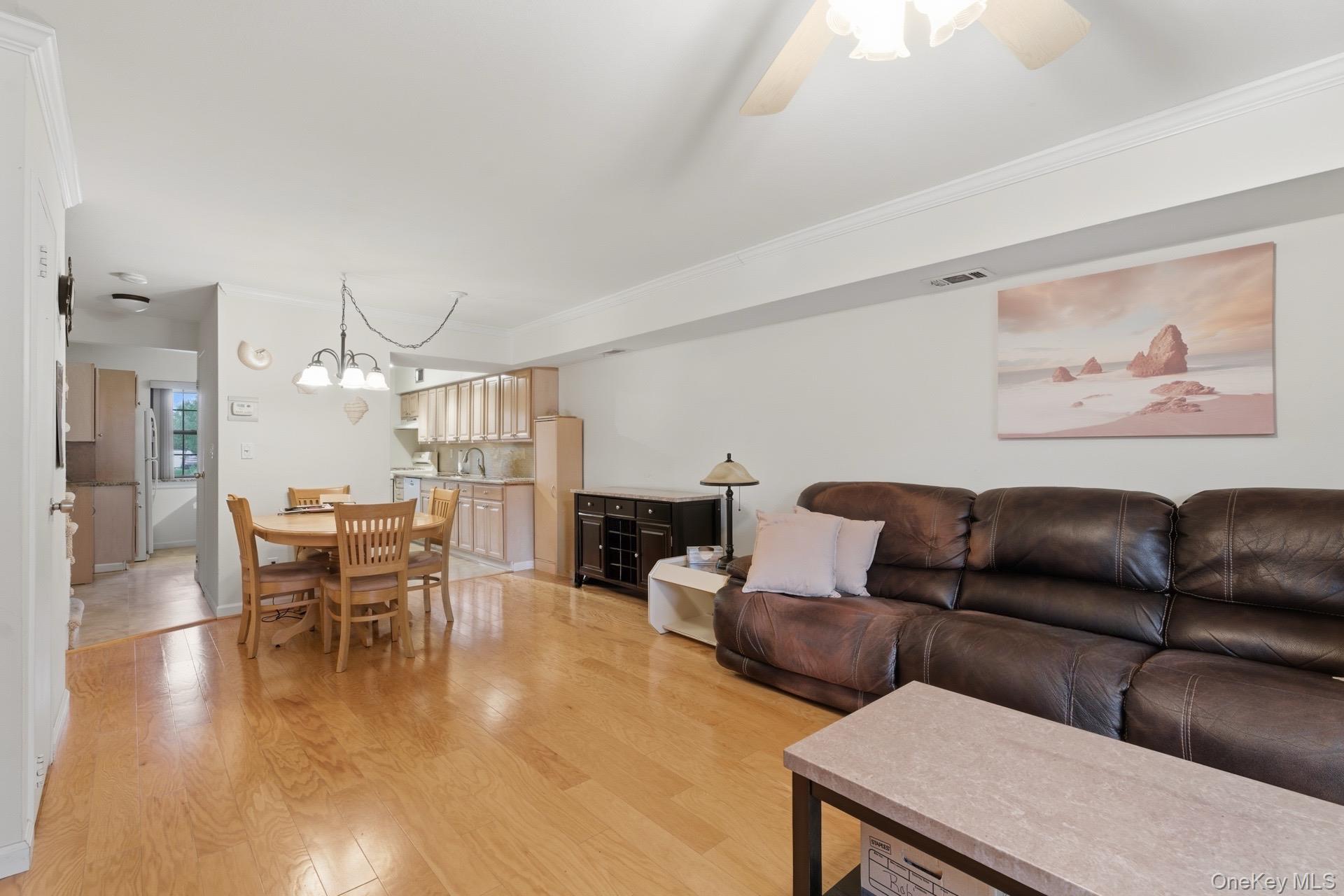 313 Mariners Way Copiague, NY 11726 - Photo 5 of 25 a living room with furniture and a dining table with kitchen view