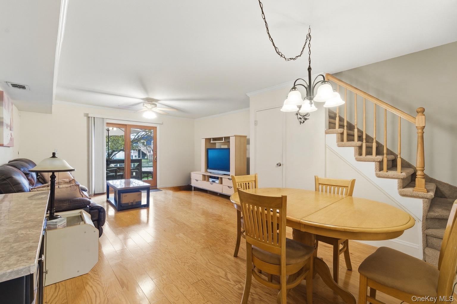 313 Mariners Way Copiague, NY 11726 - Photo 6 of 25 a dining room with furniture a chandelier and wooden floor