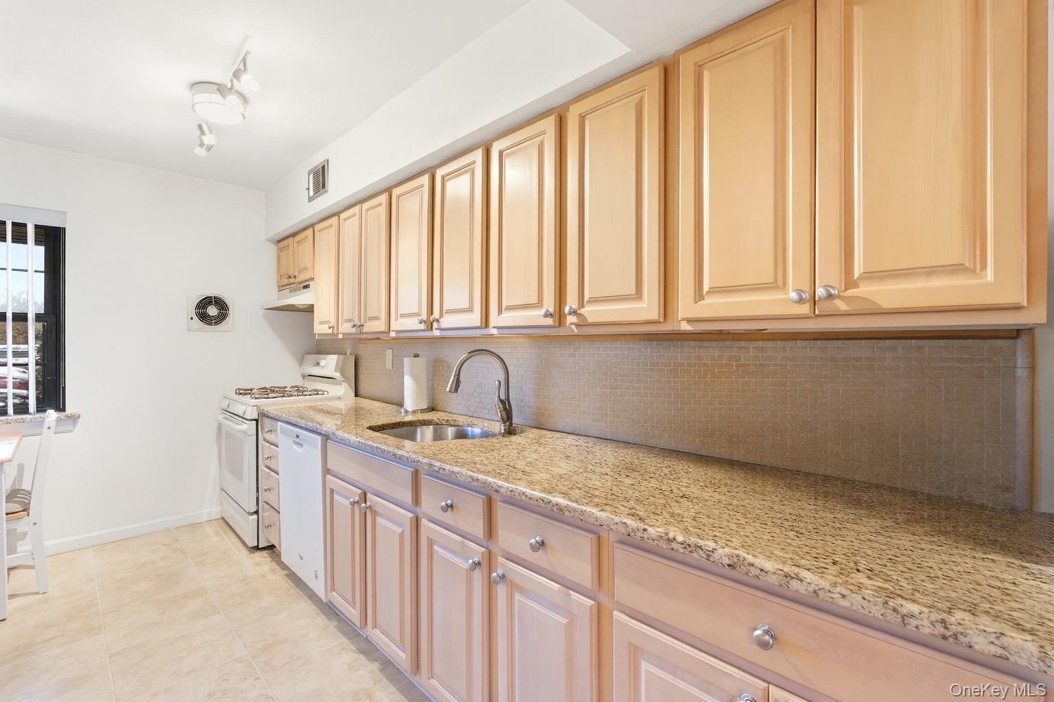 313 Mariners Way Copiague, NY 11726 - Photo 10 of 25 a kitchen with stainless steel appliances granite countertop a sink and a white cabinets