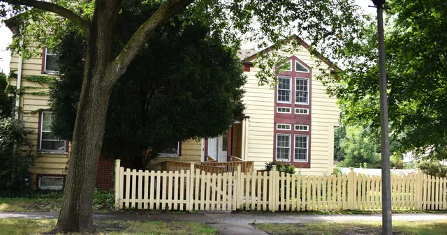 a front view of a house with a tree
