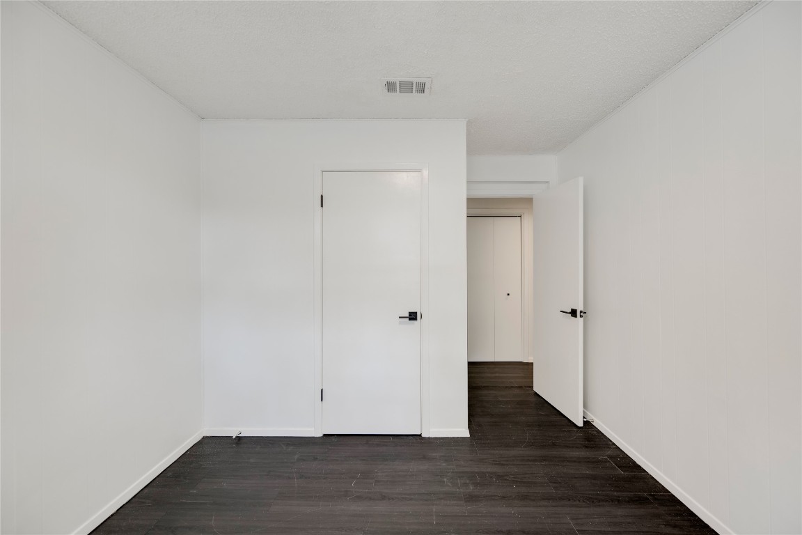 4948 Crossover Road San Marcos, TX 78666 - Photo 8 of 16 Unfurnished room featuring dark wood-type flooring and a textured ceiling