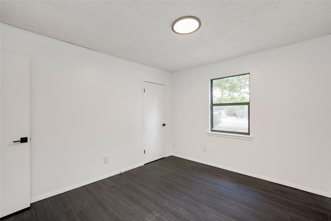 4948 Crossover Road San Marcos, TX 78666 - Photo 9 of 16 Spare room with dark wood-style floors and a textured ceiling