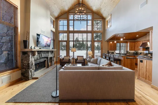 a living room with furniture a large window and kitchen view