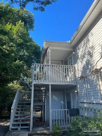 a view of house with wooden deck and furniture