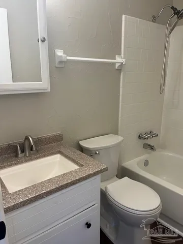 a bathroom with a granite countertop toilet sink and mirror