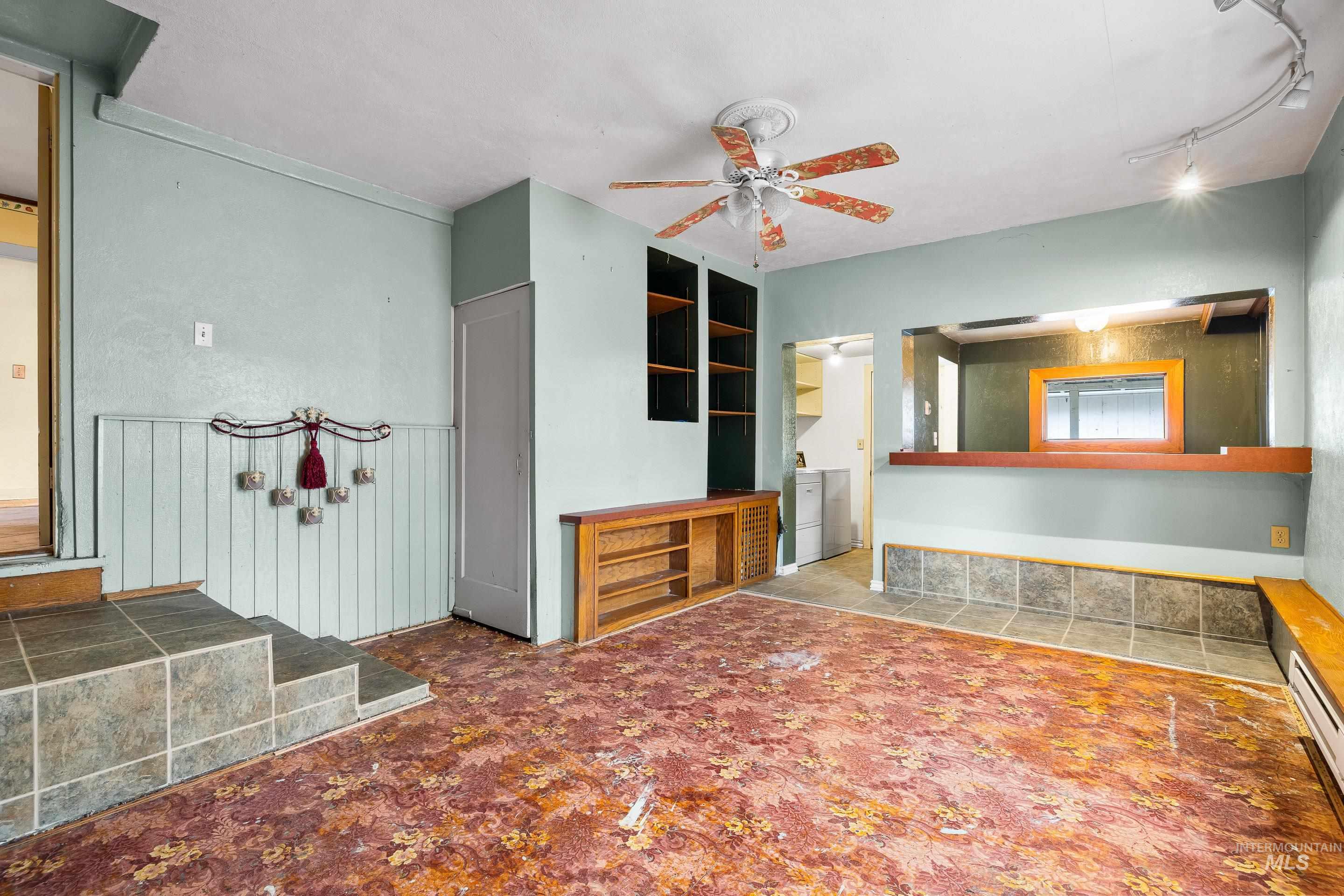 2305 South Gekeler Lane Boise, ID 83706 - Photo 18 of 33 Unfurnished living room with a baseboard radiator, a ceiling fan, and wainscoting