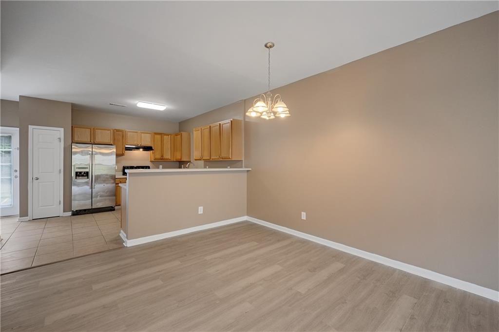 4203 Legacy Square Atlanta, GA 30349 - Photo 13 of 35 a view of a kitchen with a refrigerator wooden floor and a window