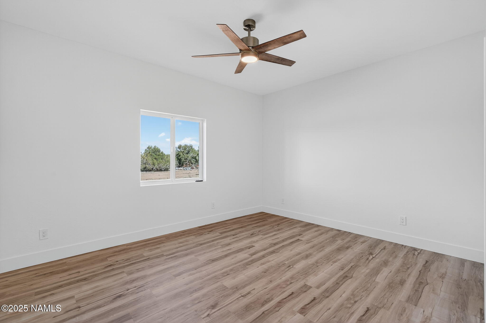 7943 North Red Lake Road Williams, AZ 86046 - Photo 24 of 33 an empty room with wooden floor and ceiling fan