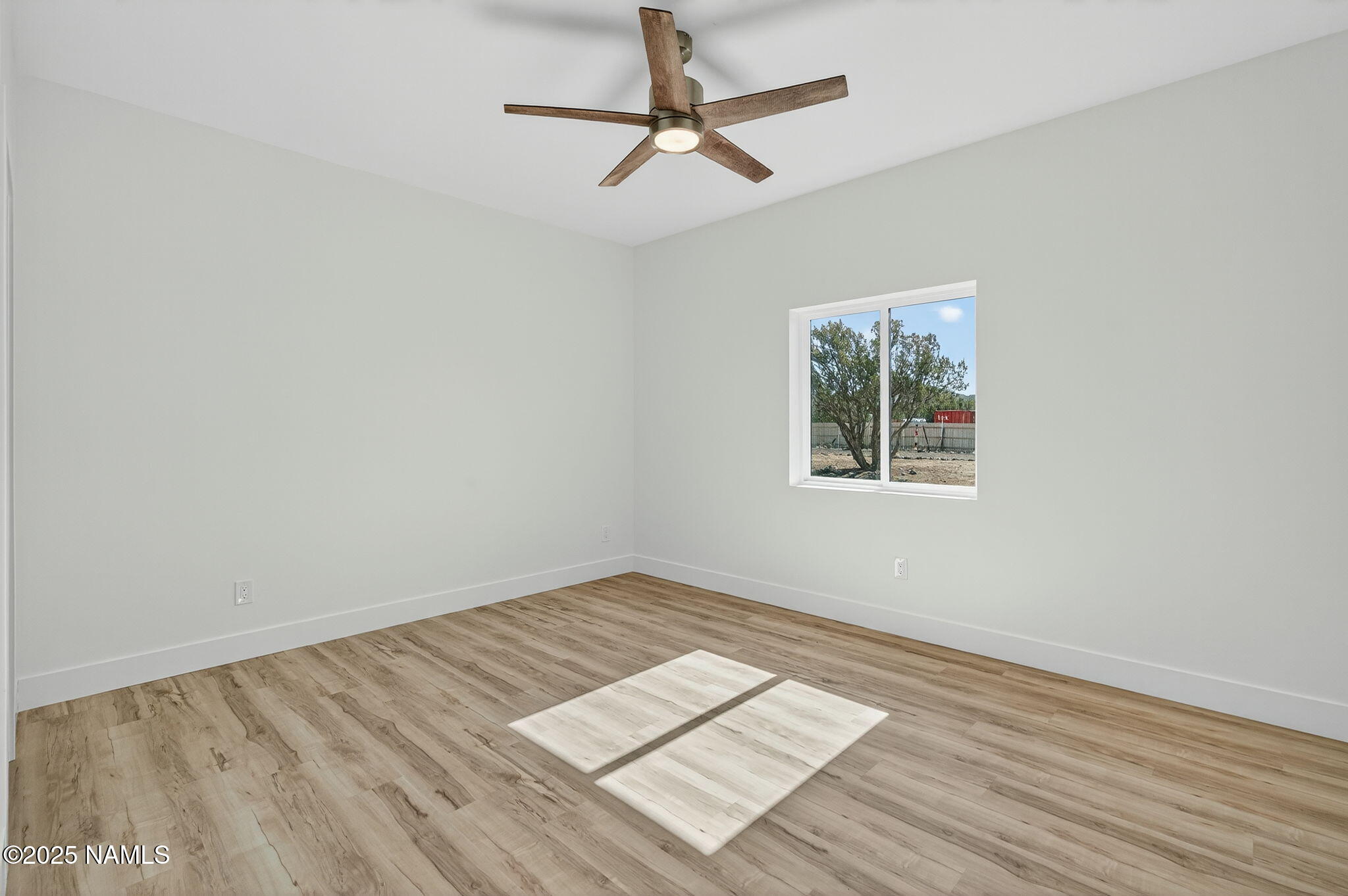 7943 North Red Lake Road Williams, AZ 86046 - Photo 25 of 33 a view of empty room with wooden floor and fan