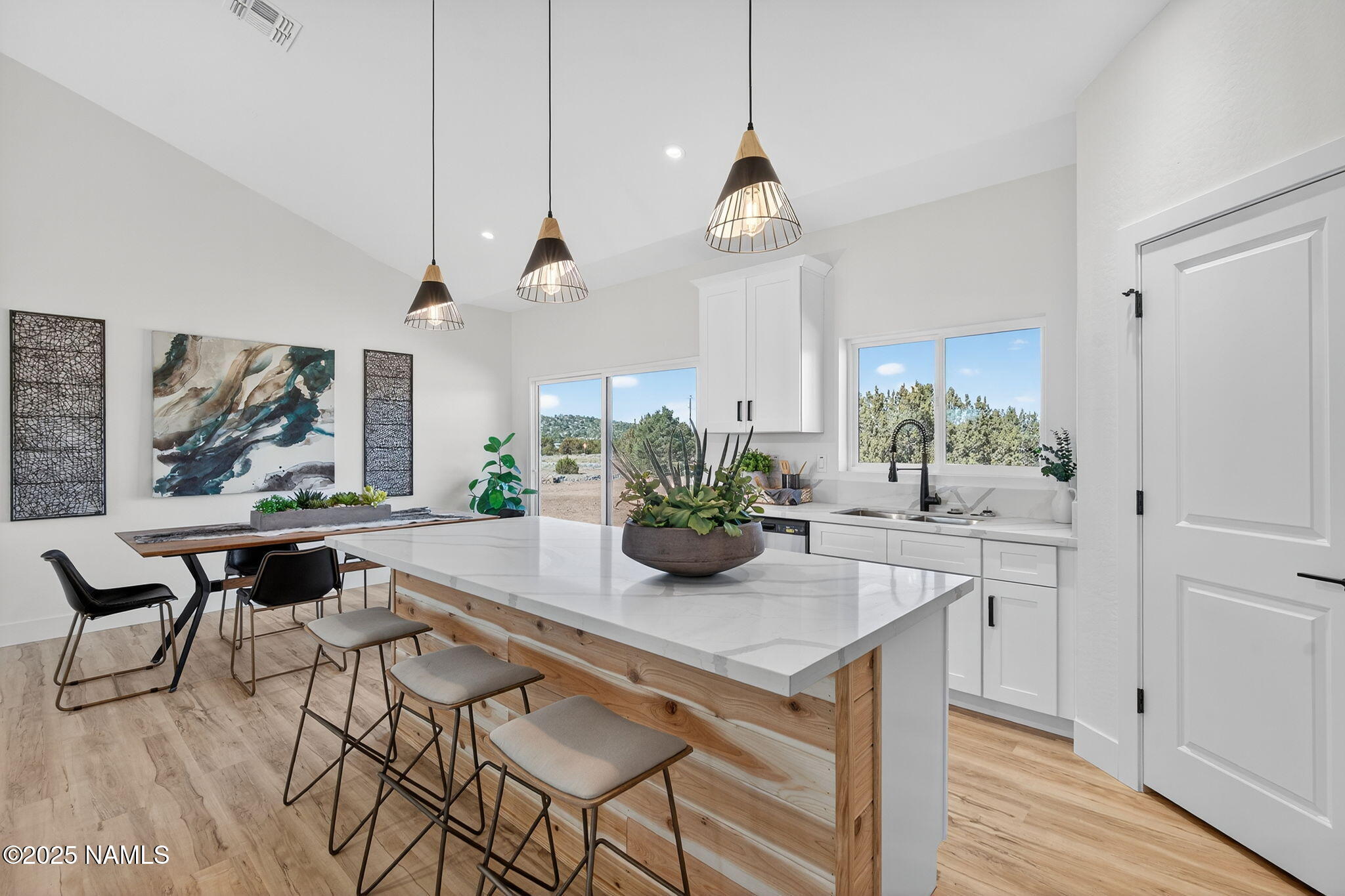 7943 North Red Lake Road Williams, AZ 86046 - Photo 8 of 33 a dining room with wooden floor a chandelier a wooden table and chairs