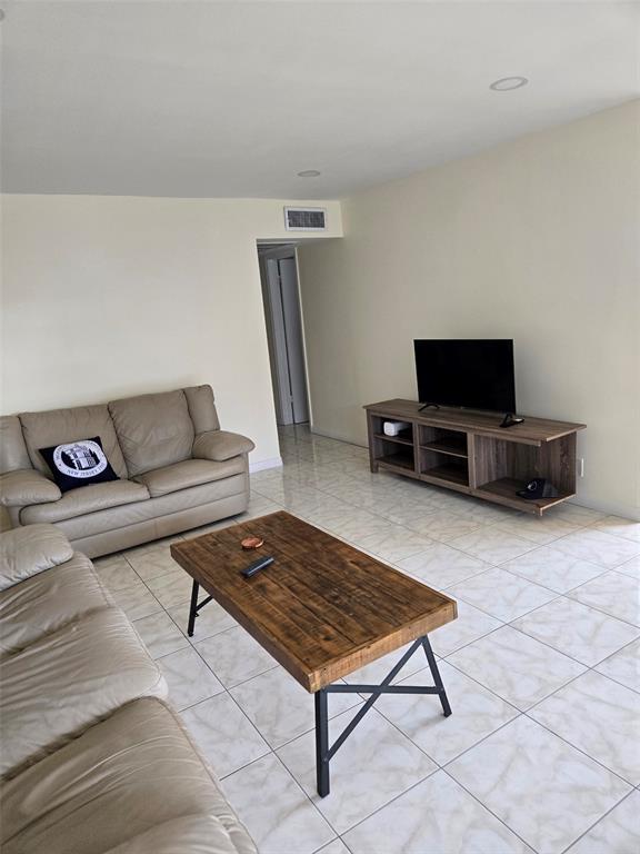 229 Durham East, Unit 229 Deerfield Beach, FL 33442 - Photo 2 of 64 a living room with furniture and a flat screen tv