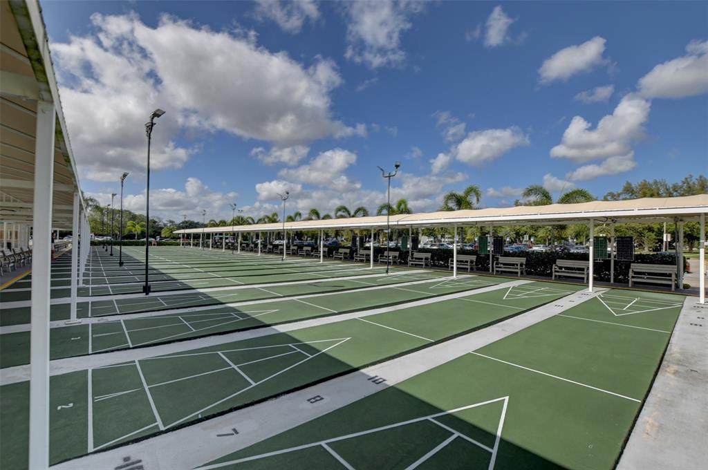 229 Durham East, Unit 229 Deerfield Beach, FL 33442 - Photo 58 of 64 a view of tennis court with lots of trees in the background