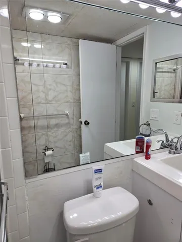 a bathroom with a sink a toilet and a mirror
