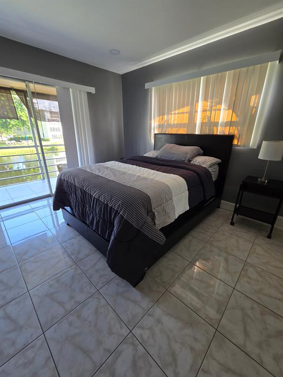 229 Durham East, Unit 229 Deerfield Beach, FL 33442 - Photo 10 of 64 a spacious bedroom with a bed and large windows