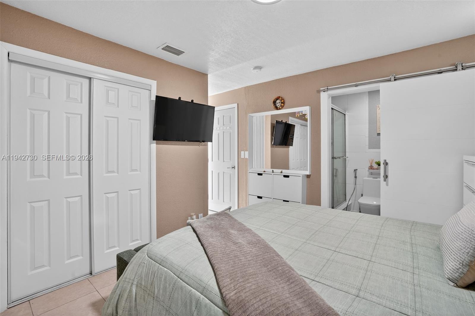 6970 Southwest 24th Street Miramar, FL 33023 - Photo 14 of 39 a bedroom with a bed and a bathroom