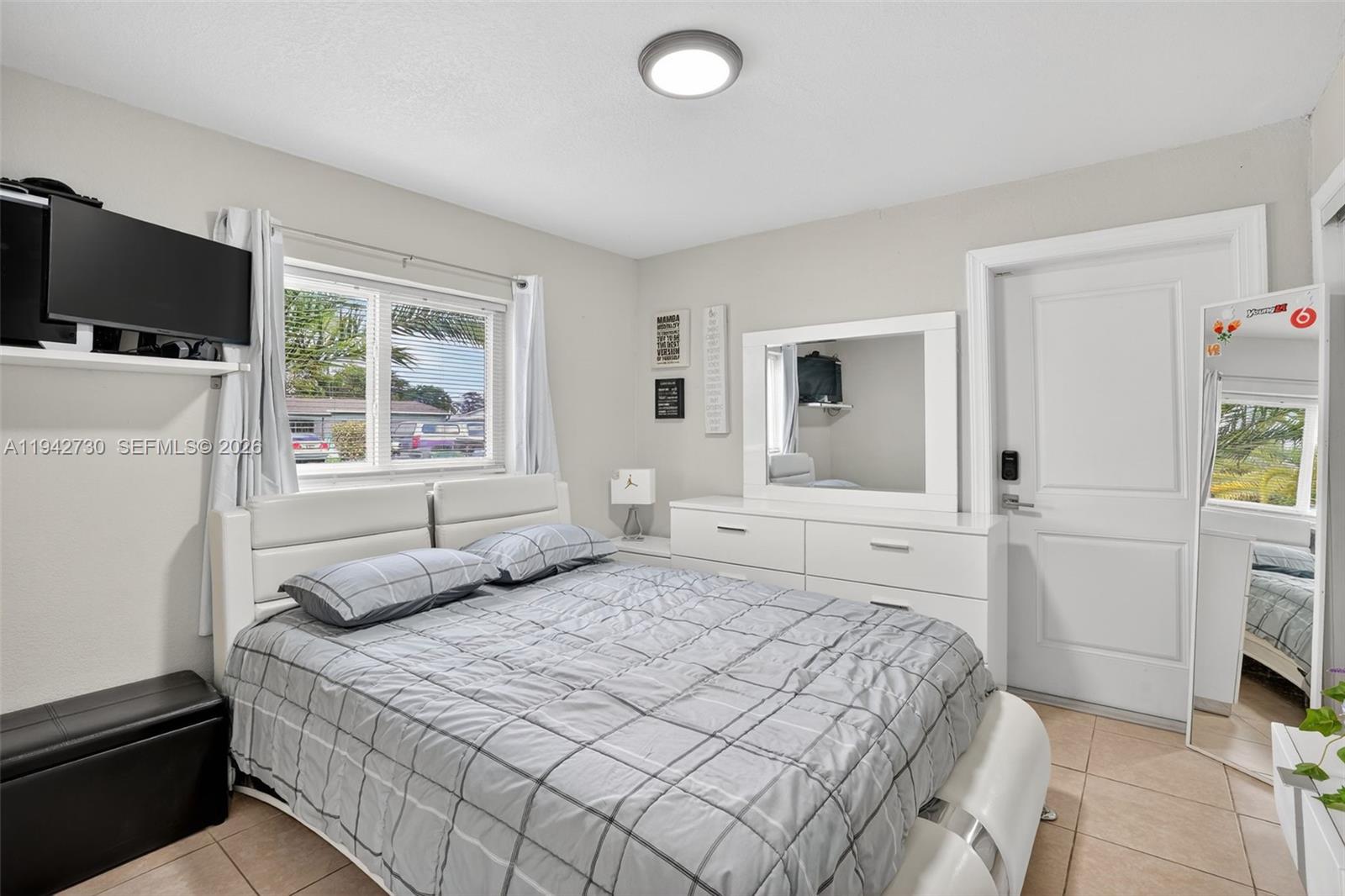 6970 Southwest 24th Street Miramar, FL 33023 - Photo 21 of 39 a bedroom with a bed and a flat screen tv