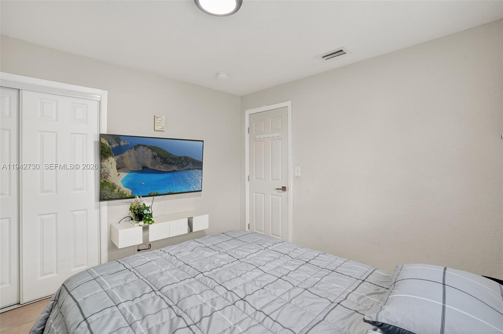 6970 Southwest 24th Street Miramar, FL 33023 - Photo 22 of 39 a bedroom with a bed and a flat screen tv