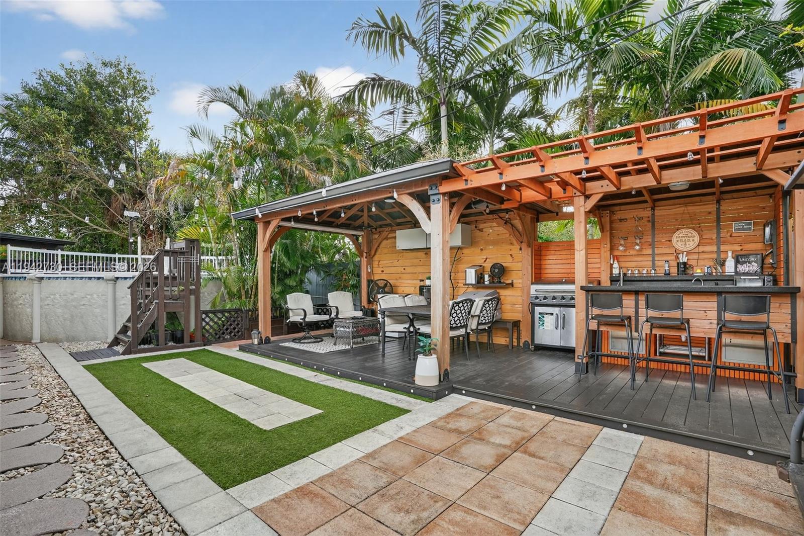 6970 Southwest 24th Street Miramar, FL 33023 - Photo 24 of 39 a view of a patio with table and chairs potted plants and large tree
