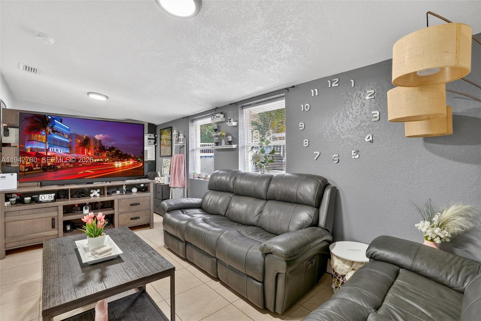 6970 Southwest 24th Street Miramar, FL 33023 - Photo 6 of 39 a living room with furniture and a flat screen tv
