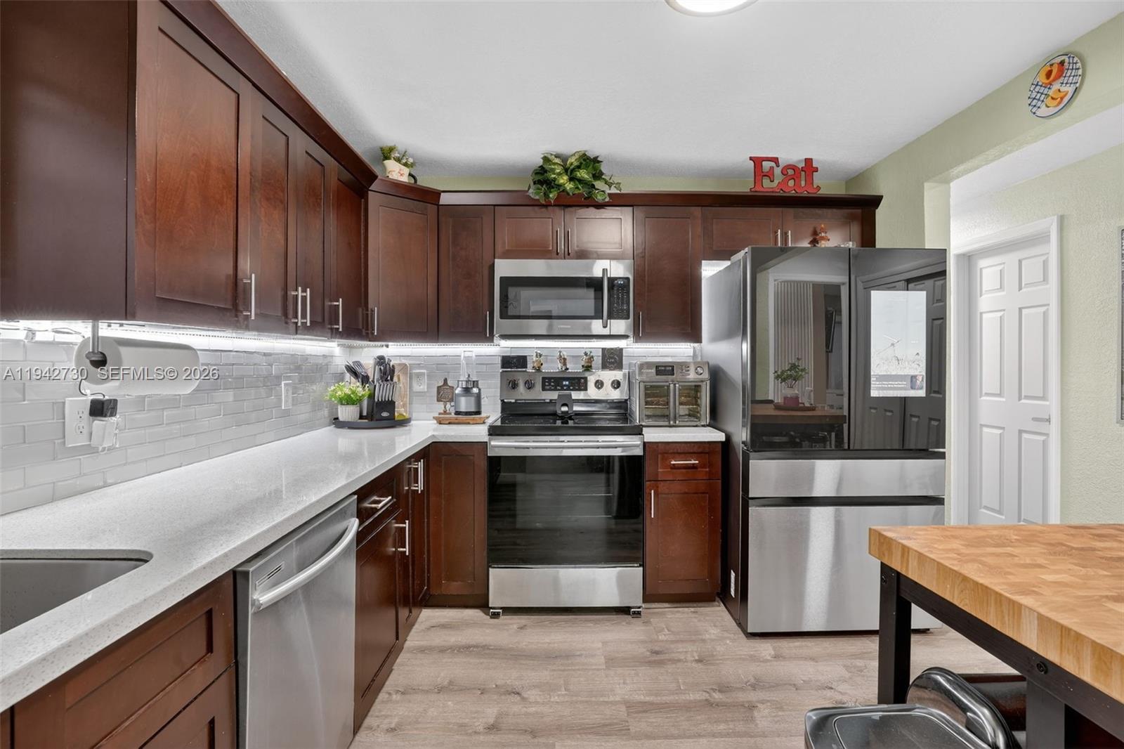 6970 Southwest 24th Street Miramar, FL 33023 - Photo 10 of 39 a kitchen with stainless steel appliances granite countertop a sink stove and refrigerator