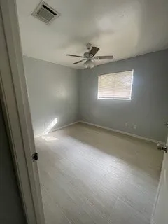 an empty room with windows and fan