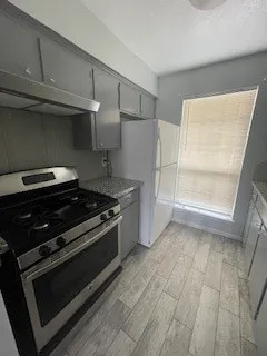 a stove top oven sitting inside of a kitchen