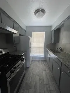 a kitchen with granite countertop a stove and a sink