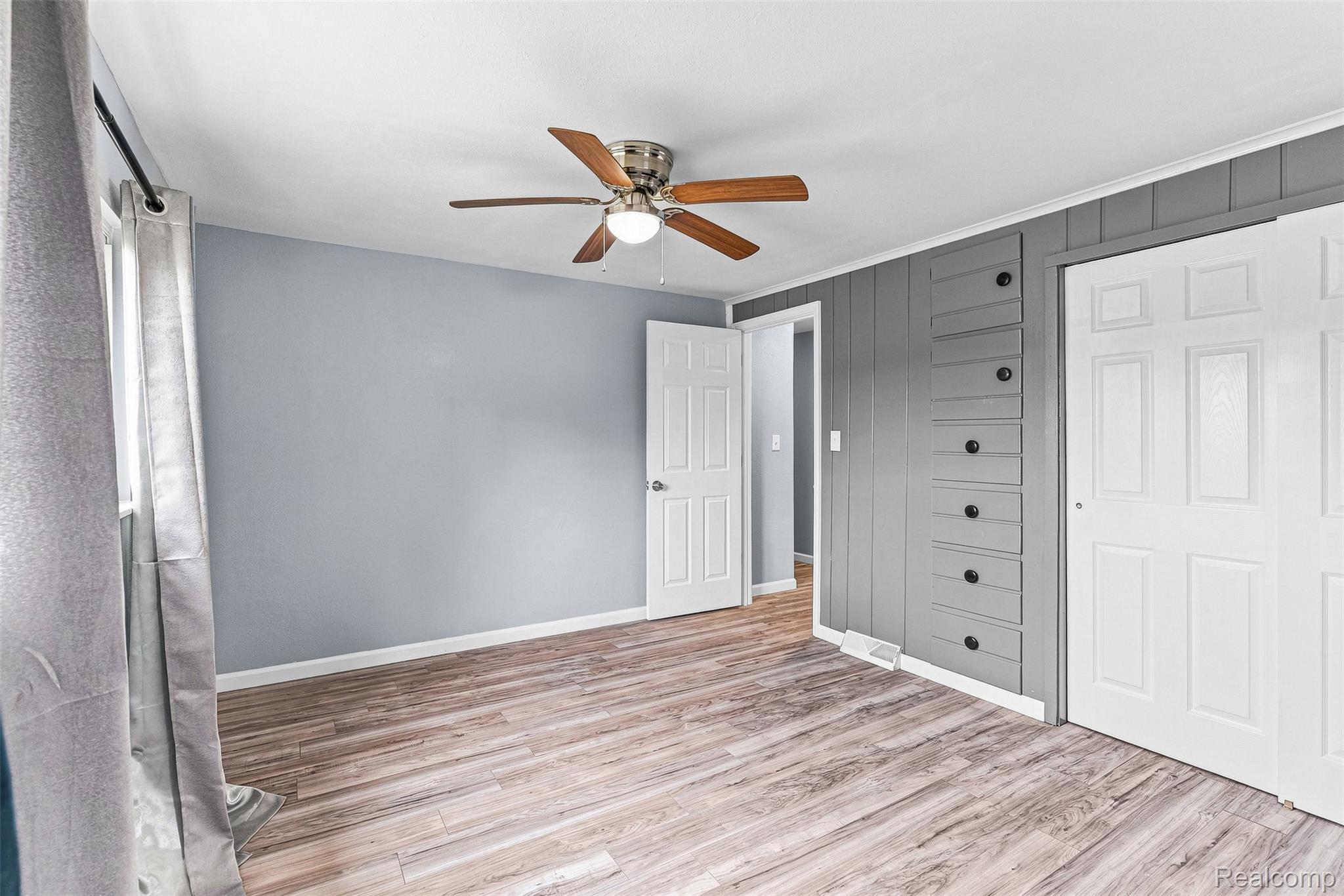 6163 North State Road Davison, MI 48423 - Photo 28 of 45 Wood-finish flooring, ceiling fan with light fixture, built-in storage drawers, and white panel doors