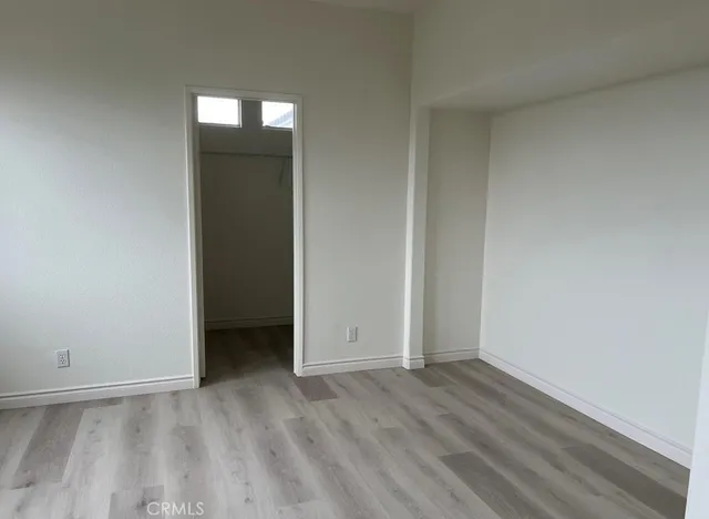 an empty room with wooden floor and closet