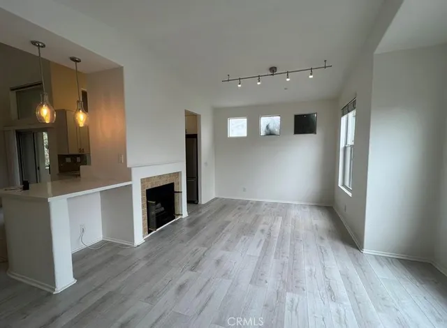an empty room with wooden floor and fireplace