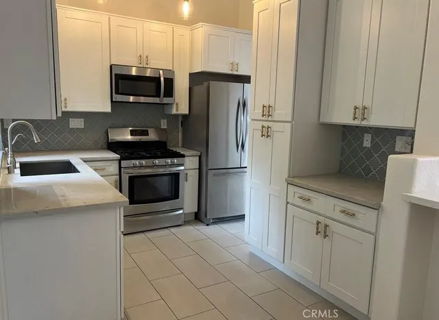 a kitchen with stainless steel appliances a refrigerator stove and microwave
