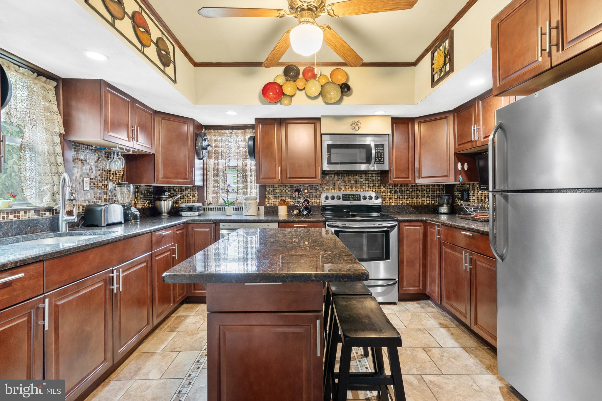 1576 Turk Road Warrington, PA 18976 - Photo 10 of 38 a kitchen with stainless steel appliances granite countertop a refrigerator a sink dishwasher a stove and a dining table with wooden floor
