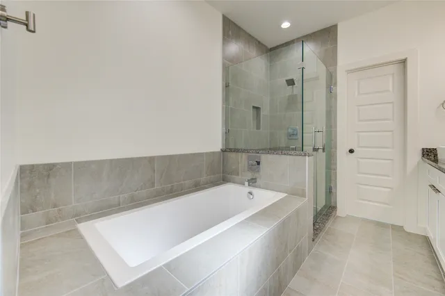 a spacious bathroom with a granite countertop sink a large mirror and shower
