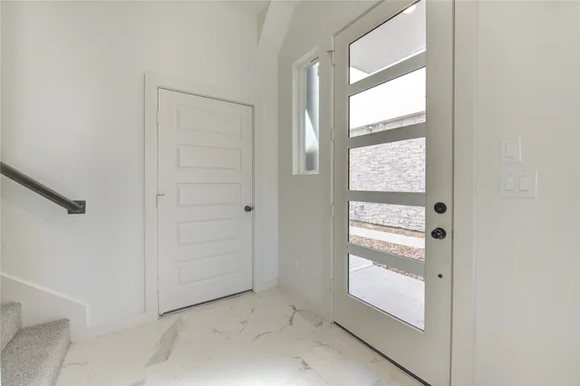 a view of a hallway with chandelier and refrigerator