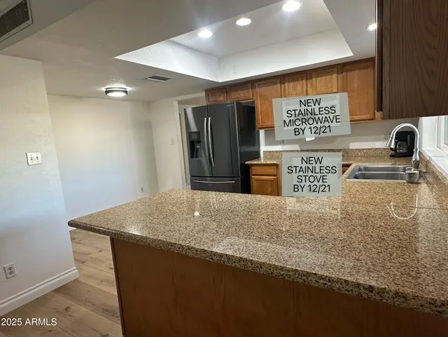 a kitchen with stainless steel appliances granite countertop a sink a stove and a refrigerator