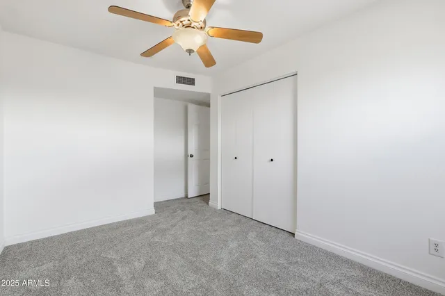 an empty room with a fan and a fan