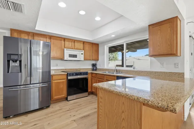 a kitchen with stainless steel appliances granite countertop a sink stove and refrigerator